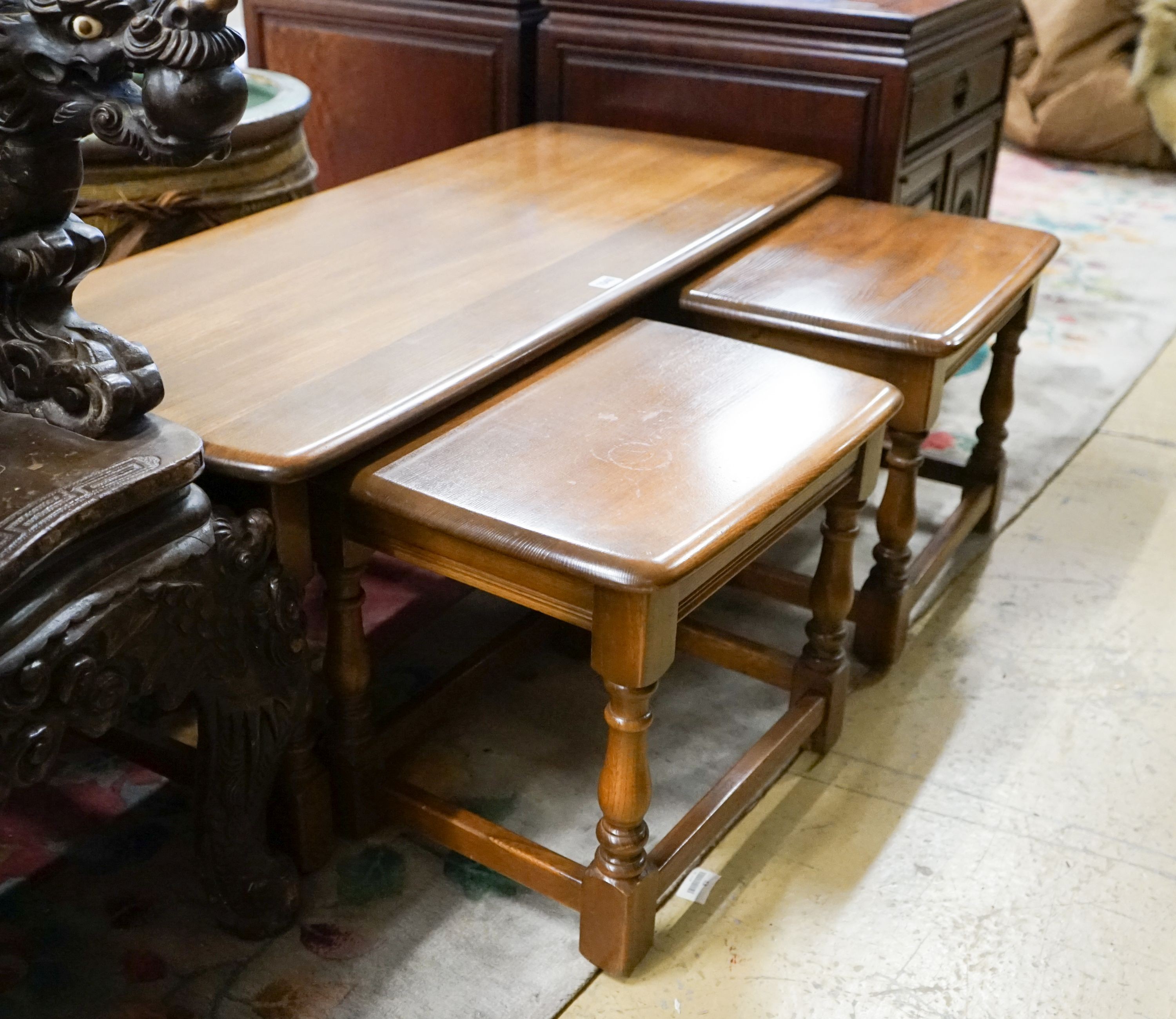 A nest of three Ercol elm tables, largest width 114cm, depth 49cm, height 41cm